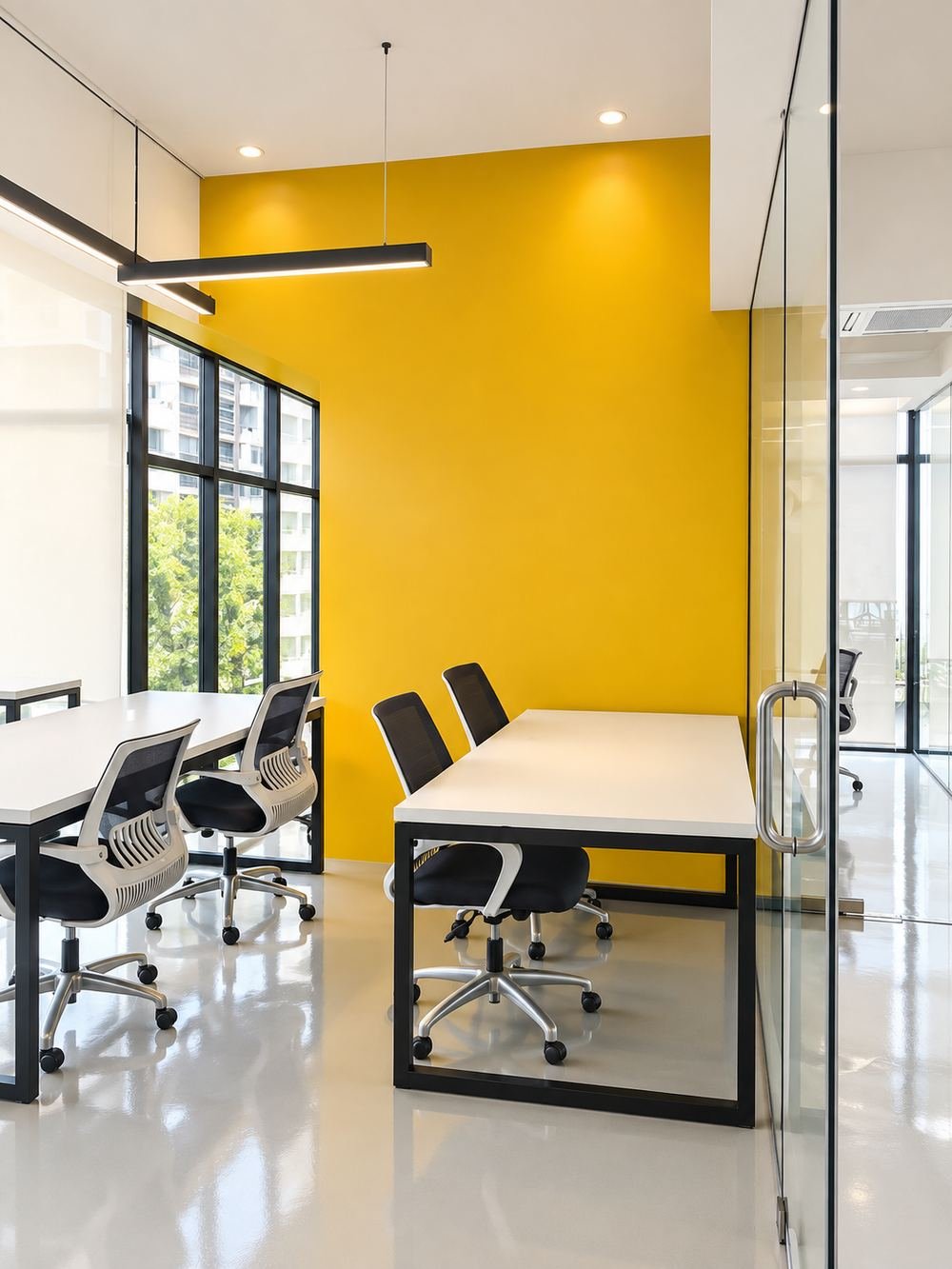 Coworking desks beside a yellow feature wall at Sirkel